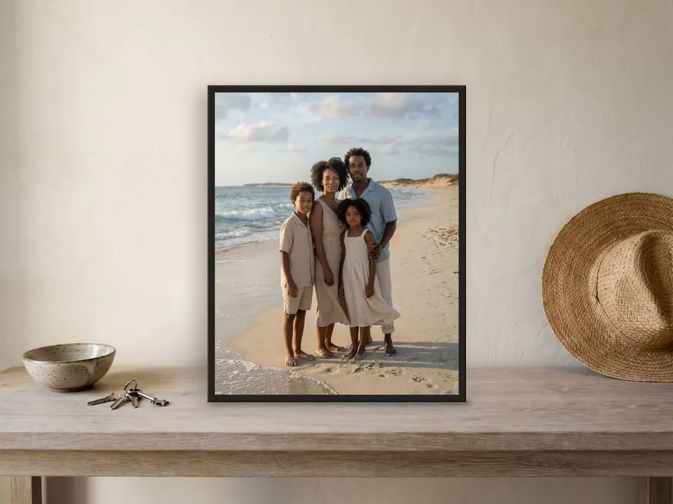Family beach photo printed in a black frame on a bleached-oak bench, with a bowl of keys and a straw hat